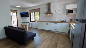 A modern kitchen with white cabinets, a built-in microwave, and a stainless steel refrigerator.