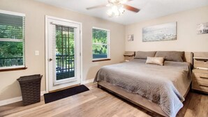 A bedroom with a bed, a ceiling fan, a window, and a door. - Tree Tops Everything is brand new (St. Augustine)