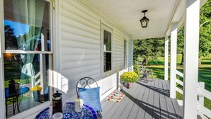 A covered porch with a table, chairs, and potted plants. - Tranquil Cottage in Virginia Countryside w/ Pond! (Midlothian)