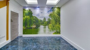 A hallway with a mural of a park scene, a wooden door, and a tiled floor.