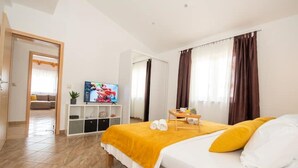 Une chambre d’hôtel avec un lit, une télévision, une petite table avec des serviettes et une vue sur un espace de vie.