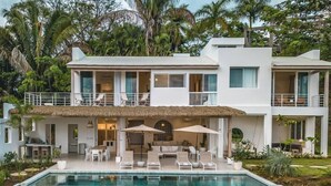 A modern two-story house with a swimming pool, outdoor seating, and lush tropical vegetation. - Casa Niri, Luxury Villa (Guanacaste Province)