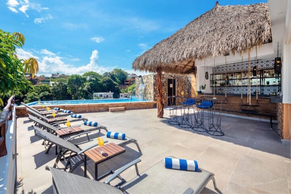 A poolside area with lounge chairs and a bar.