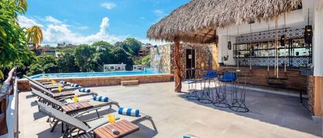 A poolside area with lounge chairs and a bar.