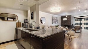 Een moderne keuken met een centraal eiland, ingebouwde apparatuur en een groot raam met uitzicht.