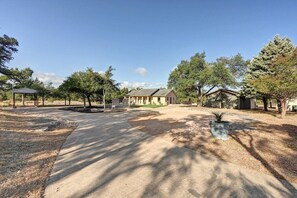 A residential area with a house, a covered pavilion, and a paved driveway. - Secluded Hill Country Retreat: Bunkhouse and Spa (Austin)