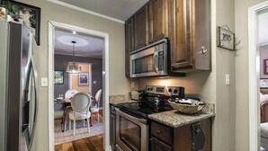 A compact kitchen with a microwave, stove, and refrigerator. - Five Points Charmer: Delightful 3BR Cottage in Five Points, Complete W/Fire Pit. (Athens)