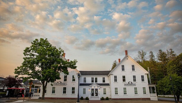 A historic building with a prominent entrance, labeled "Public House" and "Mercantile," featuring a traditional architectural style with a symmetrical facade and a central entrance.