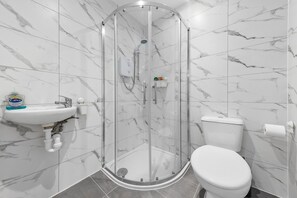A modern bathroom with a glass-enclosed shower, a white sink, and a toilet. - Cozy Ensuite Room In Feltham Hearthrow London Tw13 (Feltham)
