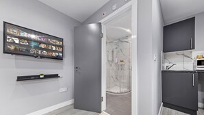 Een moderne badkamer met een douche, toilet en wastafel.