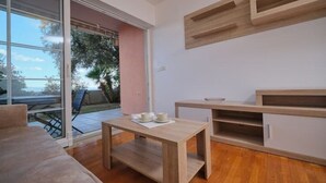 En moderne stue med en skydedør til en balkon, et træbord og indbyggede reoler.