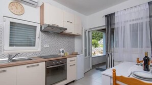 Una cucina moderna con forno a incasso, lavello e finestra con persiane.