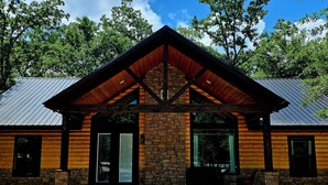Eine Lodge mit einer Stein-Fassade, Holzbalken und einem Metalldach.
