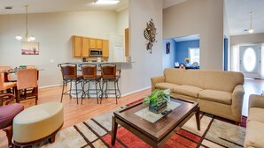 A spacious living room with a sofa, a coffee table, and a dining area with chairs and a table. - Inviting Austell Home: 14 Mi to Downtown Atlanta! (Austell)