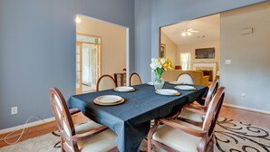A dining area with a table set for four, chairs, and a vase of flowers. - Inviting Austell Home: 14 Mi to Downtown Atlanta! (Austell)