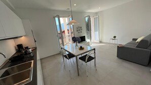 A modern apartment with a kitchen, dining area, and living room. - Lago Azzurro modern aparment with lake view and ba (Verbania)