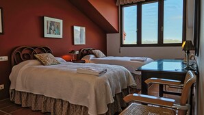 Een slaapkamer met twee bedden, een bureau en een stoel.