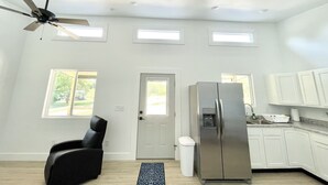 A modern kitchen with white cabinets, a stainless steel refrigerator, and a ceiling fan. - Cottage at Cave Run  (Salt Lick)