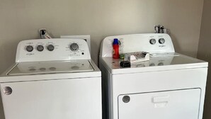 Two white stacked washer and dryer units in a room with wooden flooring. - Studio Unit in Kouts/Valparaiso 3 (Kouts)