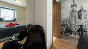 Un dormitorio con una cama, una silla, un ventanal y un mural en la pared de un edificio histórico.