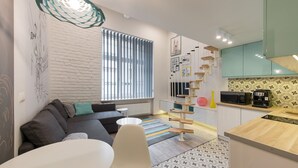 Eine moderne Küche mit Essbereich, einer Couch und einer Treppe.