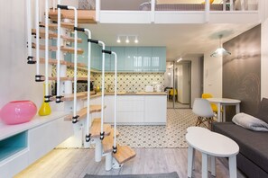 Un espacio habitable compacto con cocina, comedor y sofá.