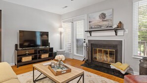 A living room with a fireplace, television, and a sofa.