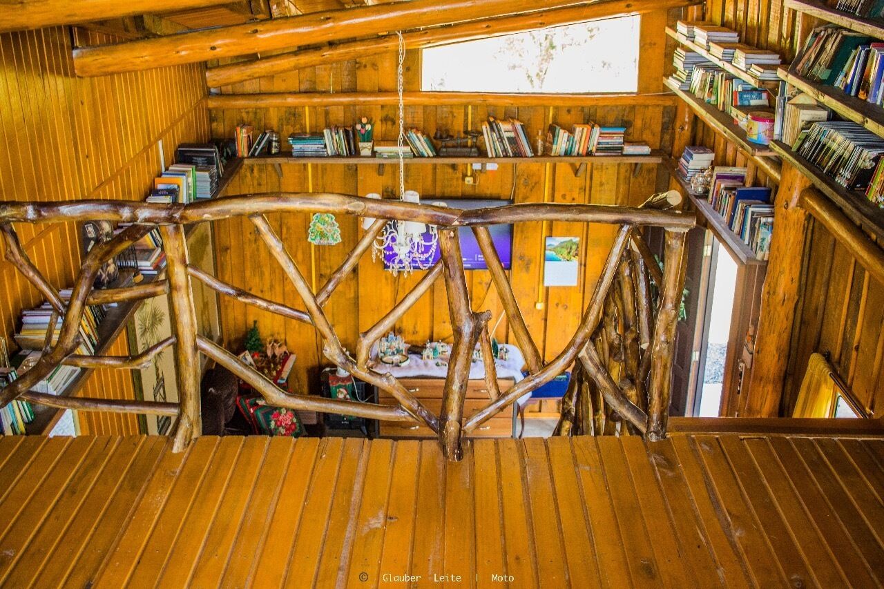 A wooden interior with bookshelves and a rustic staircase.