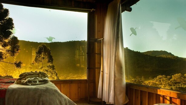 A room with a large window overlooking a forested area. - YAAHOO ECOLODGE (Bocaina do Sul)