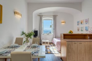 Enjoy a meal at the dining table, relax in the seating area, or take in the sea view from the large window.
