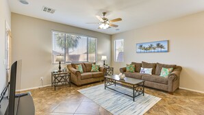 A living room with two sofas, a coffee table, a TV, and a ceiling fan. - Near Parks & Golf: Maricopa Home w/ Covered Patio! (Maricopa)