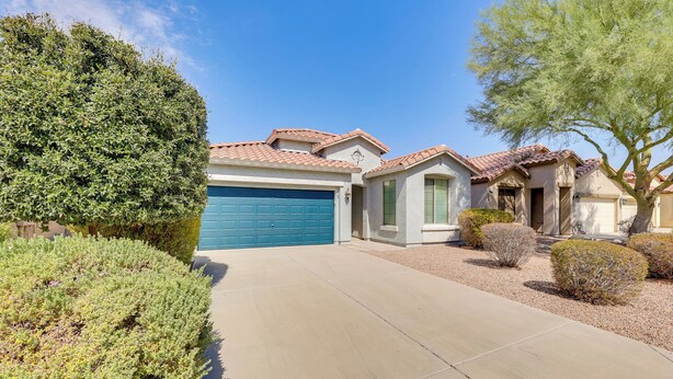 A residential area with a house featuring a blue garage door, a tiled roof, and a well-maintained lawn. - Near Parks & Golf: Maricopa Home w/ Covered Patio! (Maricopa)