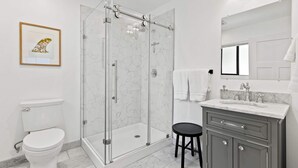 A bathroom with a toilet, a glass-enclosed shower, a sink with a mirror, and a framed picture on the wall. - Manresa Surf House 1 bed upstairs unit #4 (La Selva Beach)
