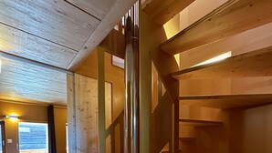 Ein Holzinnenraum mit Treppe, Holzboden und Fenster mit Blick.