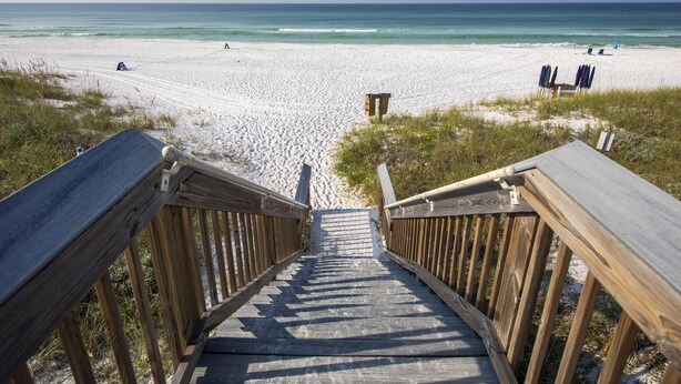 A wooden staircase leading to a beach with a sandy path and beach chairs. - San Remo by Southern Vacation Rentals (Santa Rosa Beach)