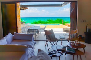 A room with a view of the ocean, a pool, and outdoor seating. - Therasia Luxury Beachfront Retreat (Dzemul)