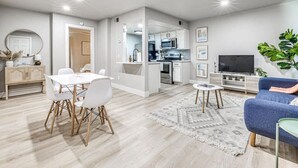 A modern apartment with a dining area, kitchen, living room, and a TV. - "The Cozy Cabana" in Paseo (Oklahoma City)