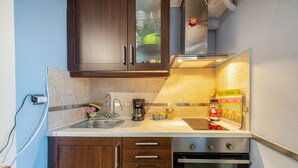 Una cocina moderna con armarios de madera oscura, un lavaplatos de acero inoxidable, una cafetera y un horno.