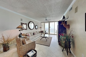 A spacious living room with a sofa, coffee table, and decorative items. - The Pearl of Navarre #1505 by Southern Vacation Rentals (Navarre)