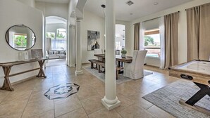 A spacious living area with a dining table, a pool table, and a large window with curtains. - Hello Sunshine! Private Heated Pool Included! (Scottsdale)