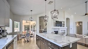 A modern kitchen with a large island, dark cabinetry, and pendant lighting. - Hello Sunshine! Private Heated Pool Included! (Scottsdale)