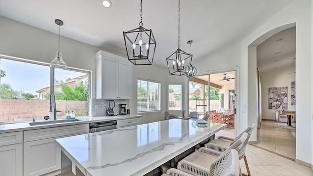 A spacious kitchen with a large island, white cabinetry, and pendant lighting. - Hello Sunshine! Private Heated Pool Included! (Scottsdale)