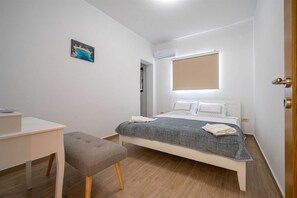 Una camera da letto moderna con un letto, una scrivania e una sedia.