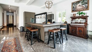 Une cuisine moderne dotée d’un îlot central, de tabourets de bar et d’un meuble en bois.