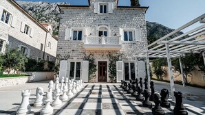 Un bâtiment en pierre doté d’un balcon et d’un échiquier placé devant l’entrée.