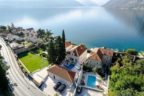 Une propriété située sur la côte, dotée d’une piscine, d’un court de tennis et d’un chemin menant à la propriété.