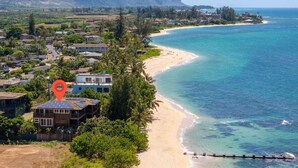 A coastal residential area with houses, a beach, and a view of the ocean.