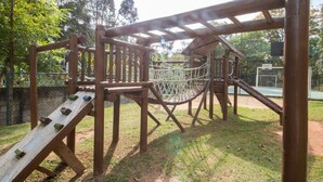 A wooden playground structure with a slide, climbing net, and a rope bridge. - 3 Bedrooms - Modern - Close to the Mall (São Paulo)