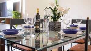 A dining table set with blue bowls, wine glasses, and a bottle of wine. - 3 Bedrooms - Modern - Close to the Mall (São Paulo)
