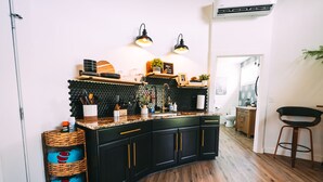 A modern kitchen with black cabinets, a wooden countertop, and a black hexagonal backsplash.